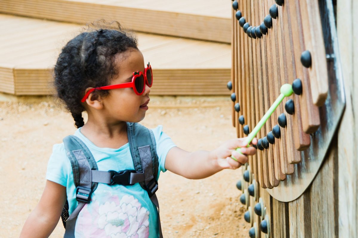 A girl playing on an instrument outdoors