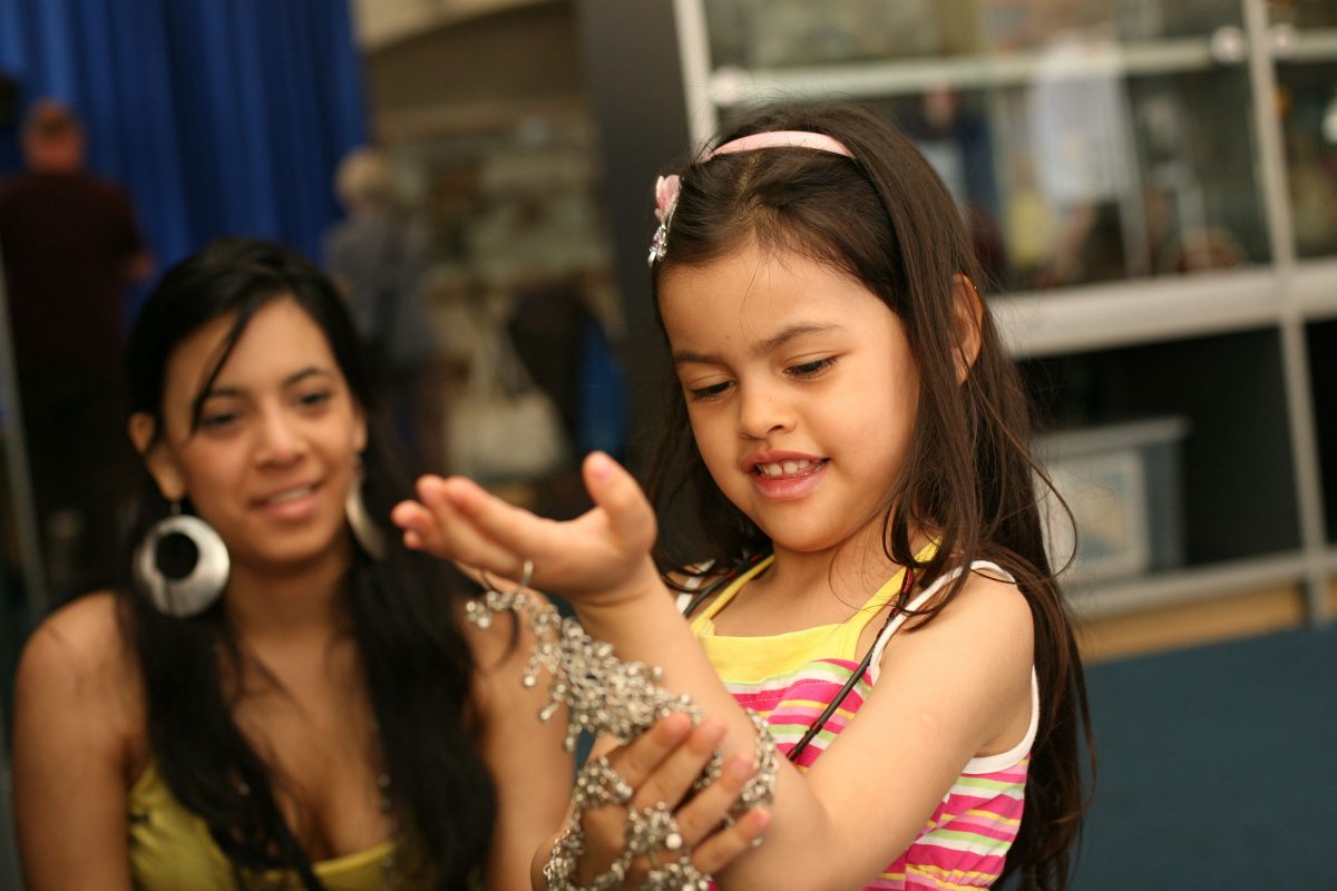 A girl is trying on jewelry in the Hands On Base