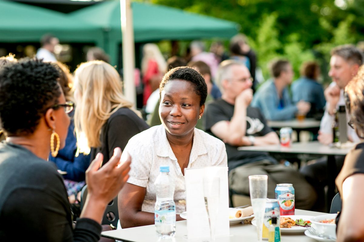 Two women at a table in a garden talking