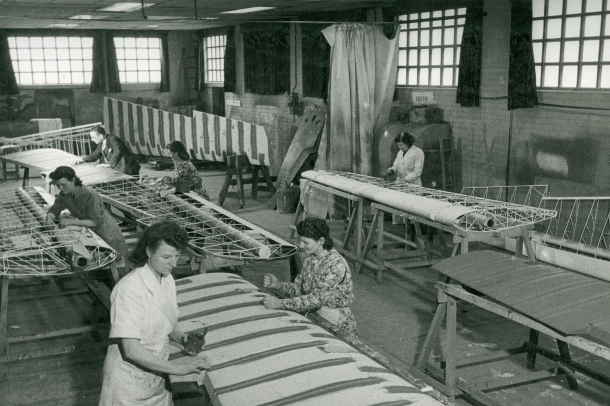 Black and white image of people working on panels.