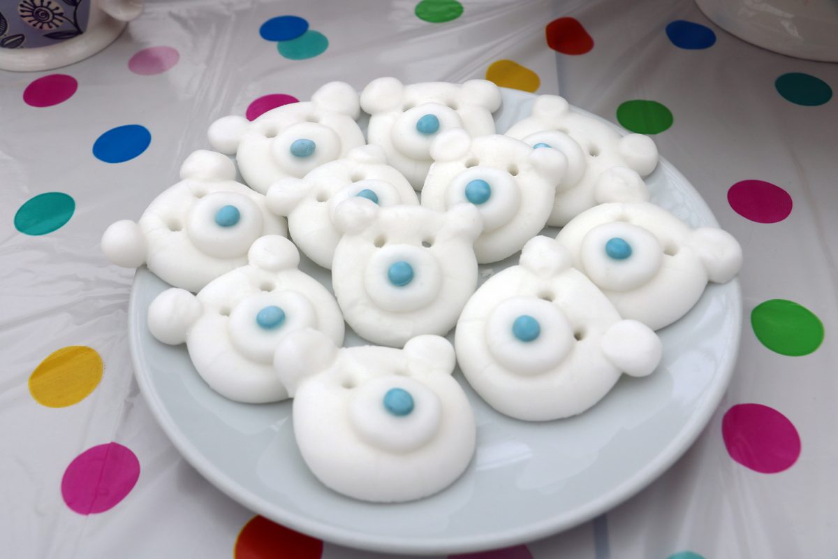 Sweets shaped like bear's face on a plate.