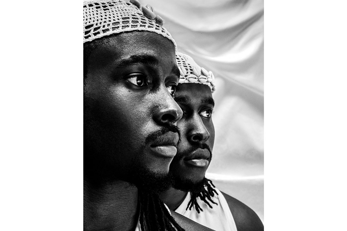 Black and white photo of two black men, faces half seen