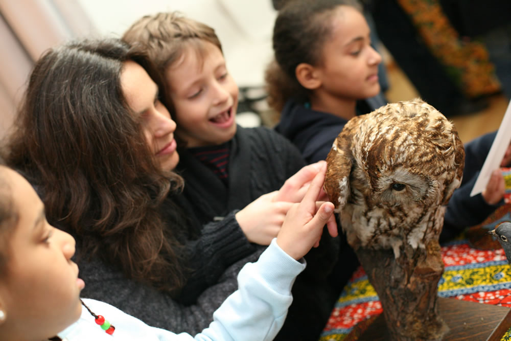 Woman and three children handling owl specimen