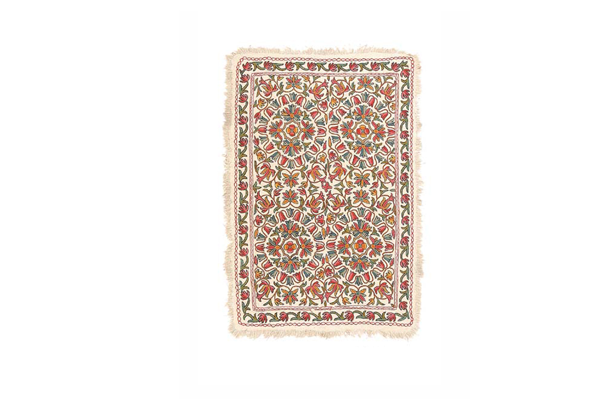 Rectangular cream floor felt or rug ('numdah') with multicoloured chain stitch embroidery.