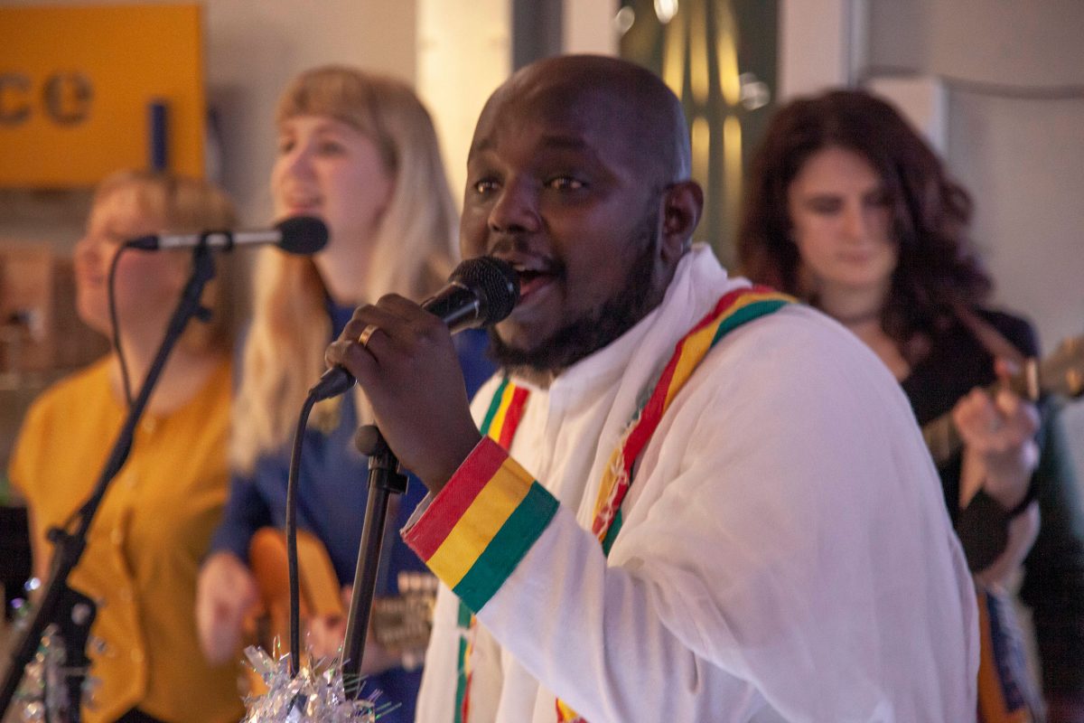 A man singing with females singers behind