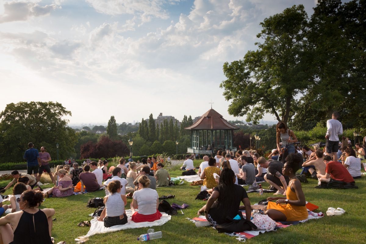 People enjoying music on the Horniman Bandstand, sat on the grass