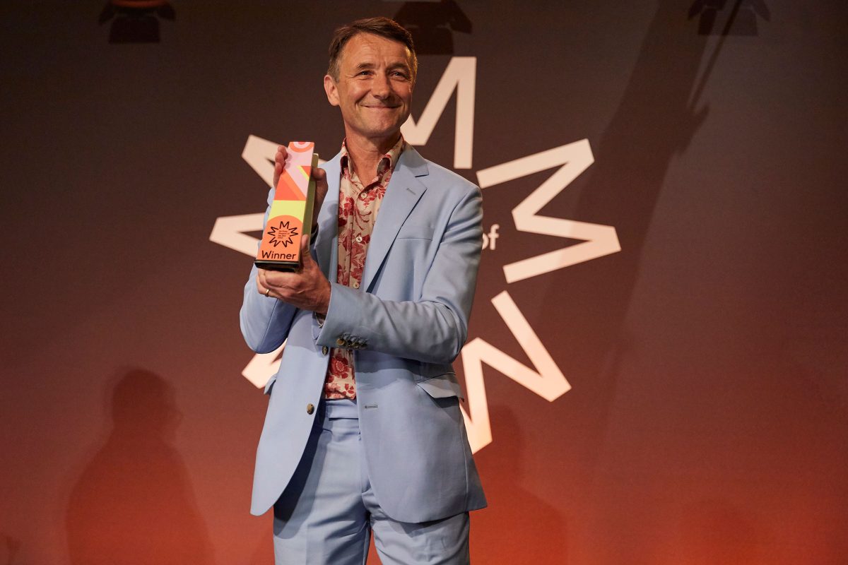 Nick Merriman smiling with the museum of the year award