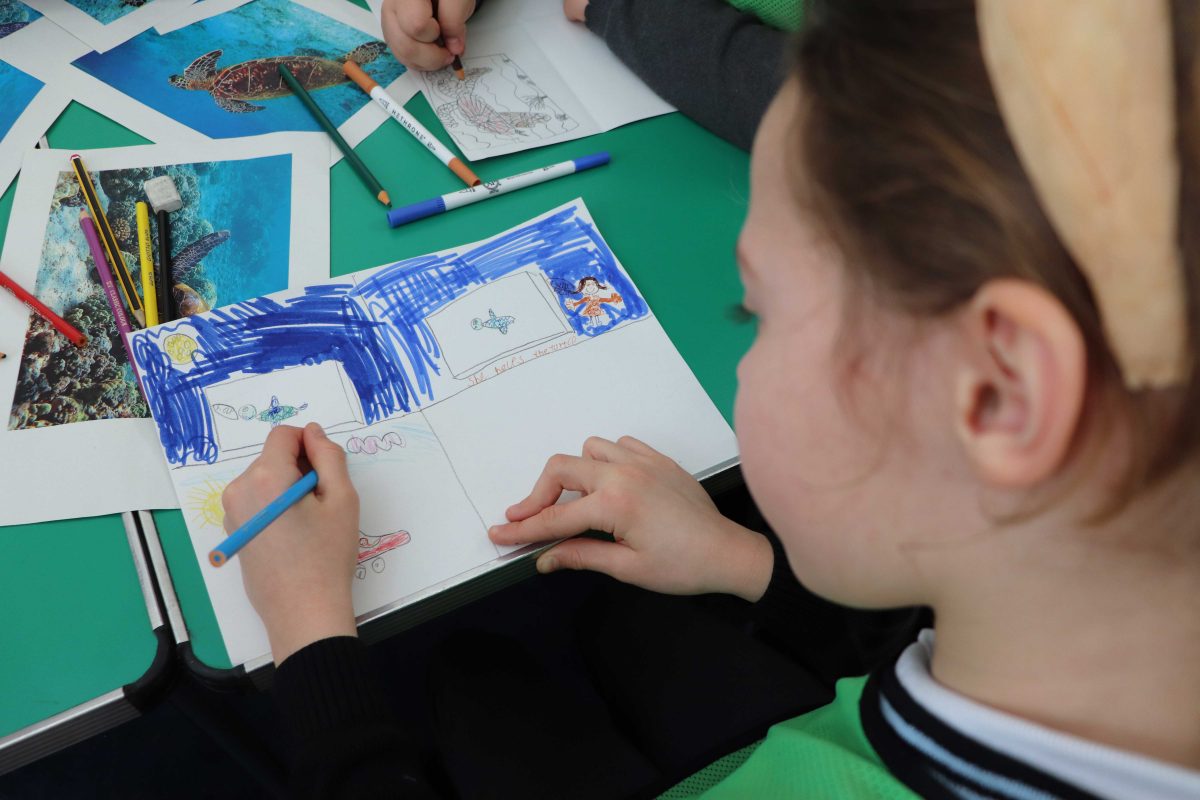 View over the shoulder of a child doing a drawing