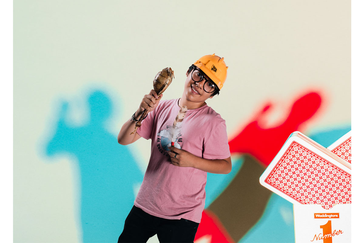 Photo of a young man edited to look small,he is holding a feather and wearing a hard hat